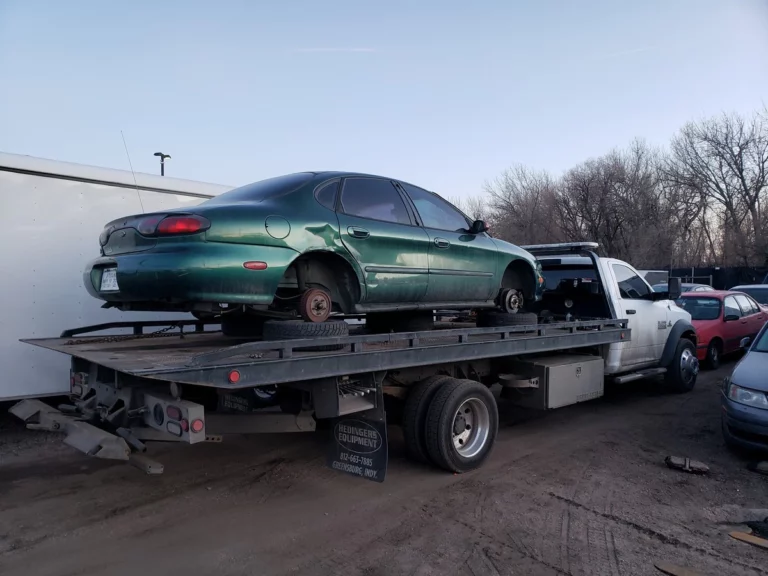 Old green sedan bought for cash and loaded on Jorge's tow truck in Arvada, CO