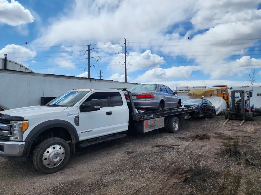 Free junk car towing: a sedan loaded on Jorge's flatbed in Englewood, CO