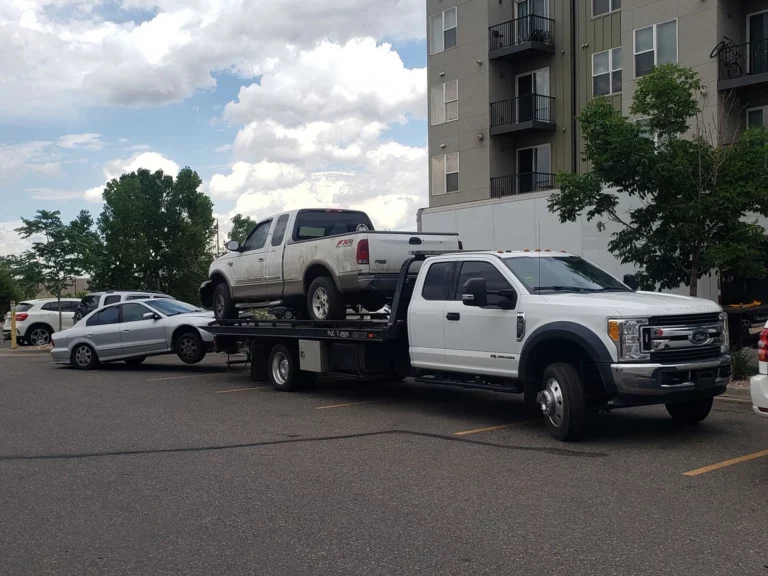 Scrap pickup truck loaded on Jorge's flatbed tow truck in Lakewood, CO