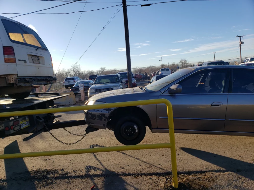 Jorge's tow truck hooking up an old car for cash in Littleton, CO